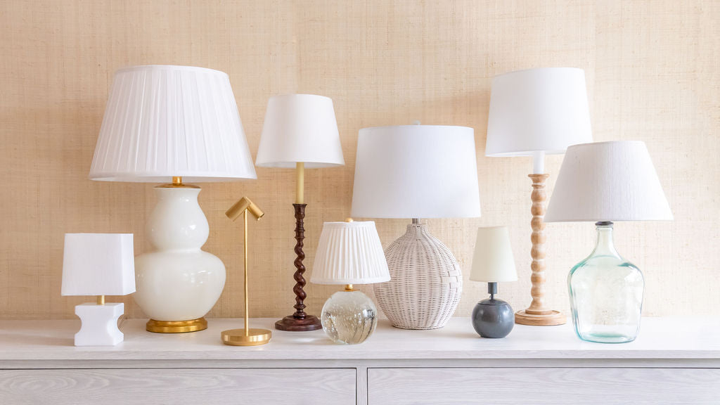 Collection of various table lamps on a light-colored surface with a neutral background