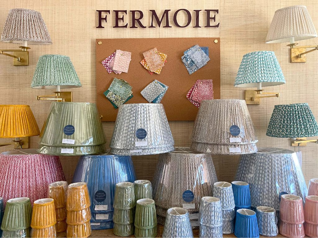 Display of colorful lampshades with 'Fermoie' branding on a wall.