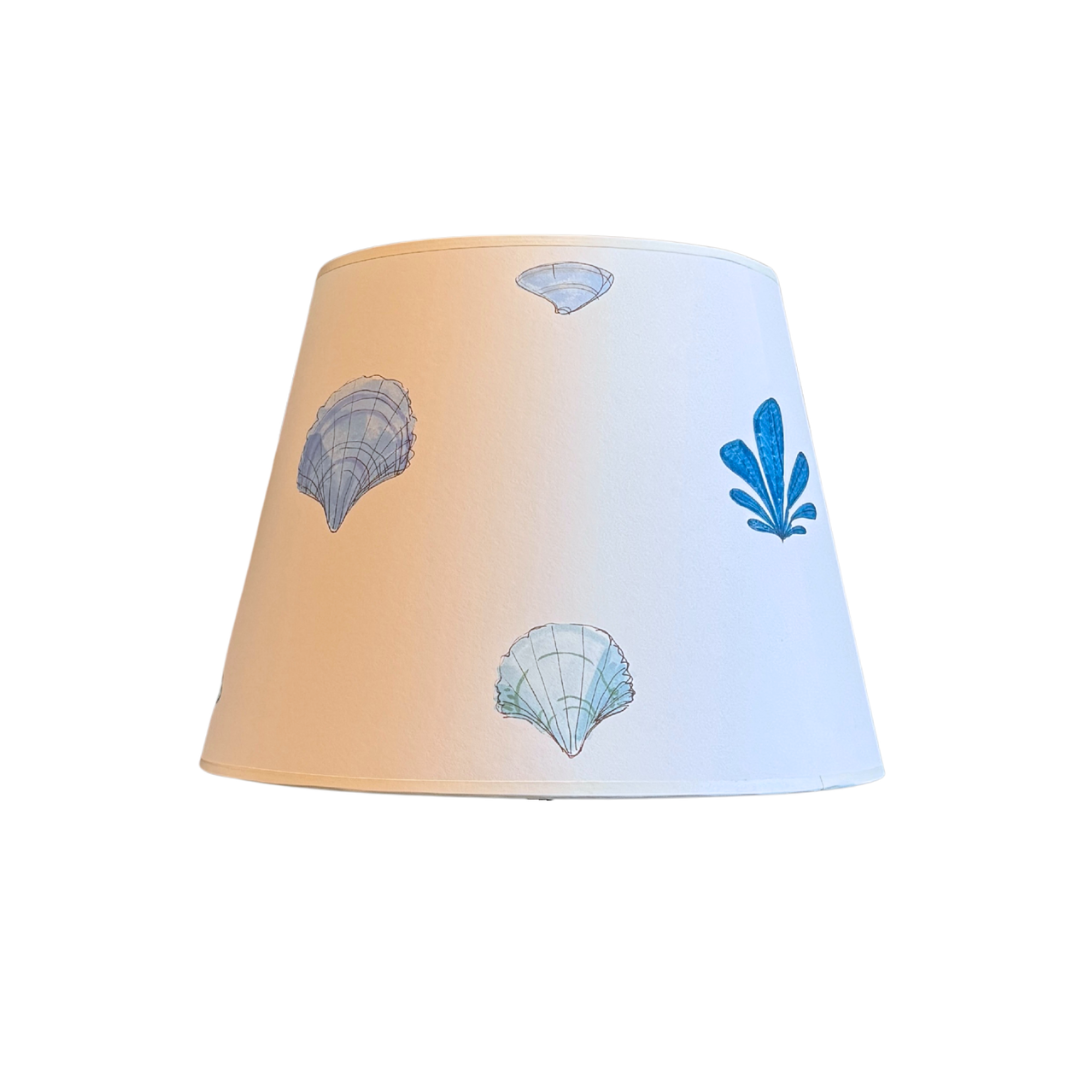 Lampshade with blue shell designs on a white background