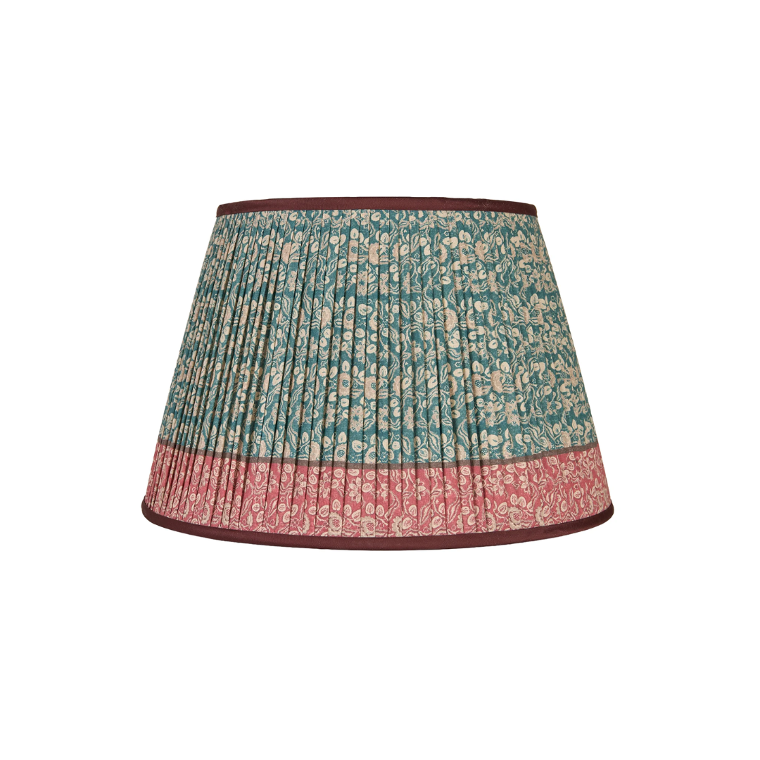 A pleated fabric Penny Morrison lampshade with a teal and pink floral pattern and dark brown trim, shown against a plain white background.
